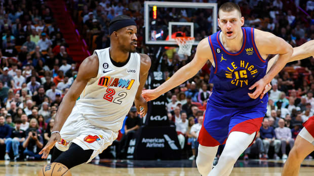 Heat’s Jimmy Butler dribbles past Nuggets’ Nikola Jokić.